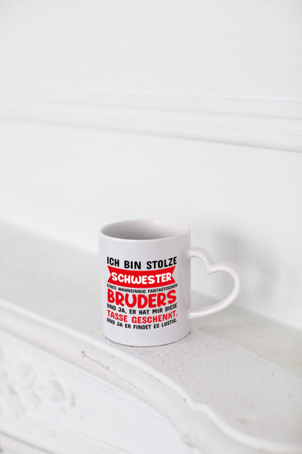 Ich bin stolze Schwester - Herzhenkel Tasse - Kaffeetasse / Geschenk / Familie