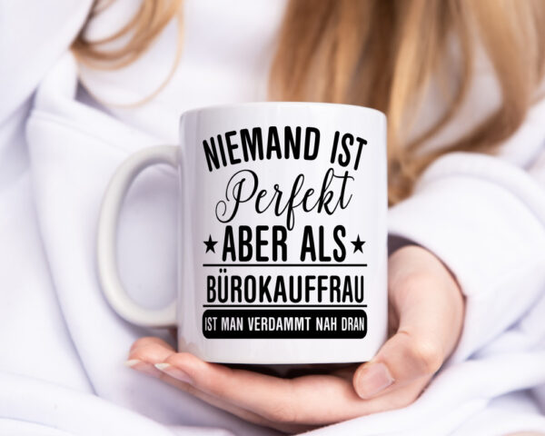 Verdammt nah dran: Bürokauffrau | Kauffrau - Tasse Weiss - Kaffeetasse / Geschenk / Familie