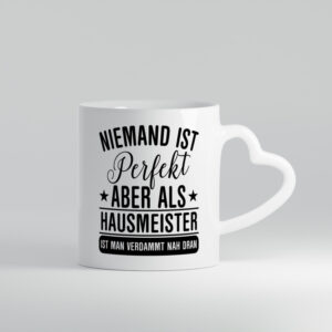 Verdammt nah dran: Hausmeister | Hauswart - Herzhenkel Tasse - Kaffeetasse / Geschenk / Familie