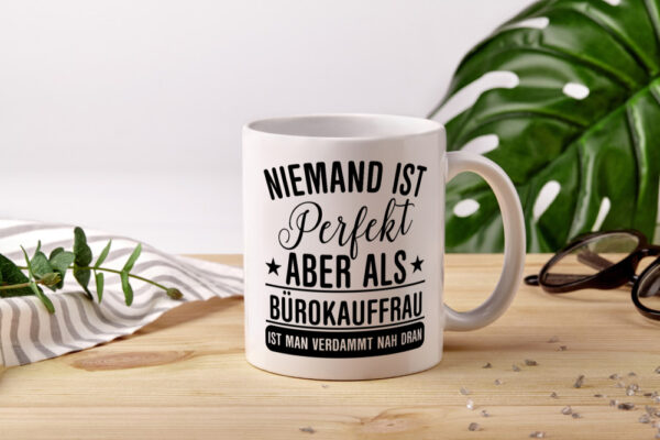 Verdammt nah dran: Bürokauffrau | Kauffrau - Tasse Weiss - Kaffeetasse / Geschenk / Familie