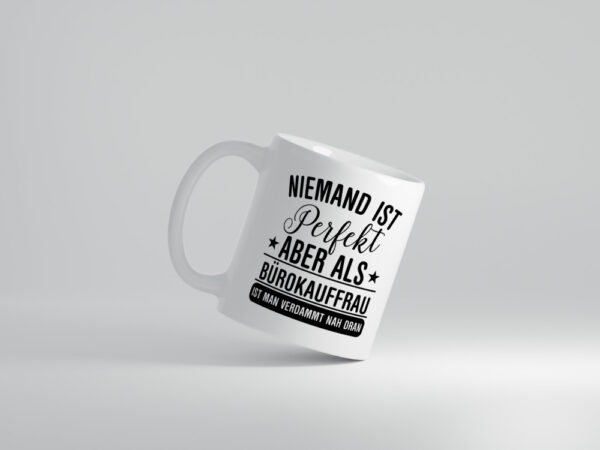 Verdammt nah dran: Bürokauffrau | Kauffrau - Tasse Weiss - Kaffeetasse / Geschenk / Familie