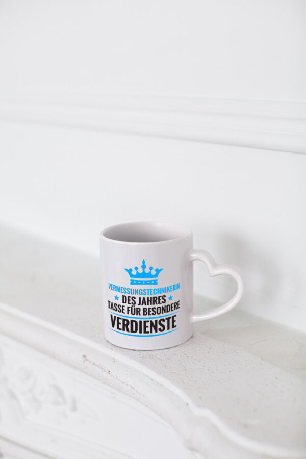 Besonderer Verdienst: Vermessungstechnikerin | Techniker - Herzhenkel Tasse - Kaffeetasse / Geschenk / Familie