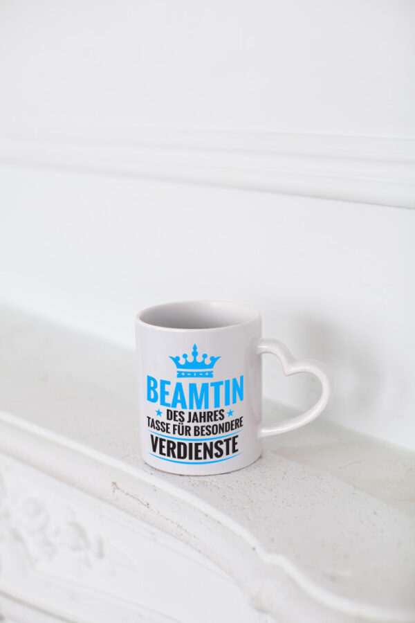 Besonderer Verdienst: Beamtin | Verbeamtung | Dienst - Herzhenkel Tasse - Kaffeetasse / Geschenk / Familie