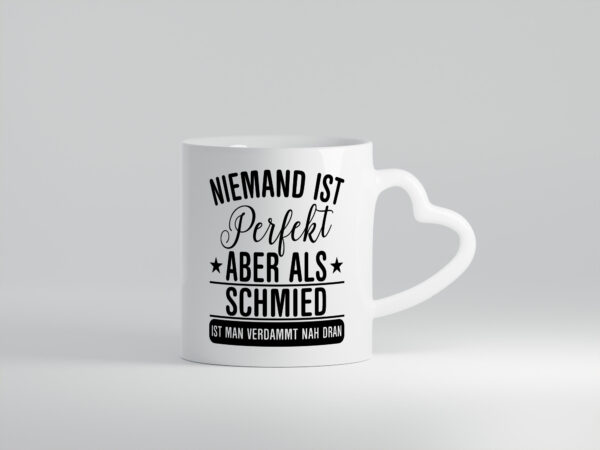 Verdammt nah dran: Schmied | schmieden - Herzhenkel Tasse - Kaffeetasse / Geschenk / Familie